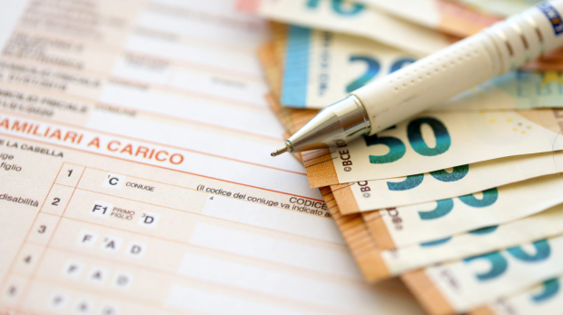 Filling italian tax form process with pen and euro money bills close up. Tax paying period and deadline